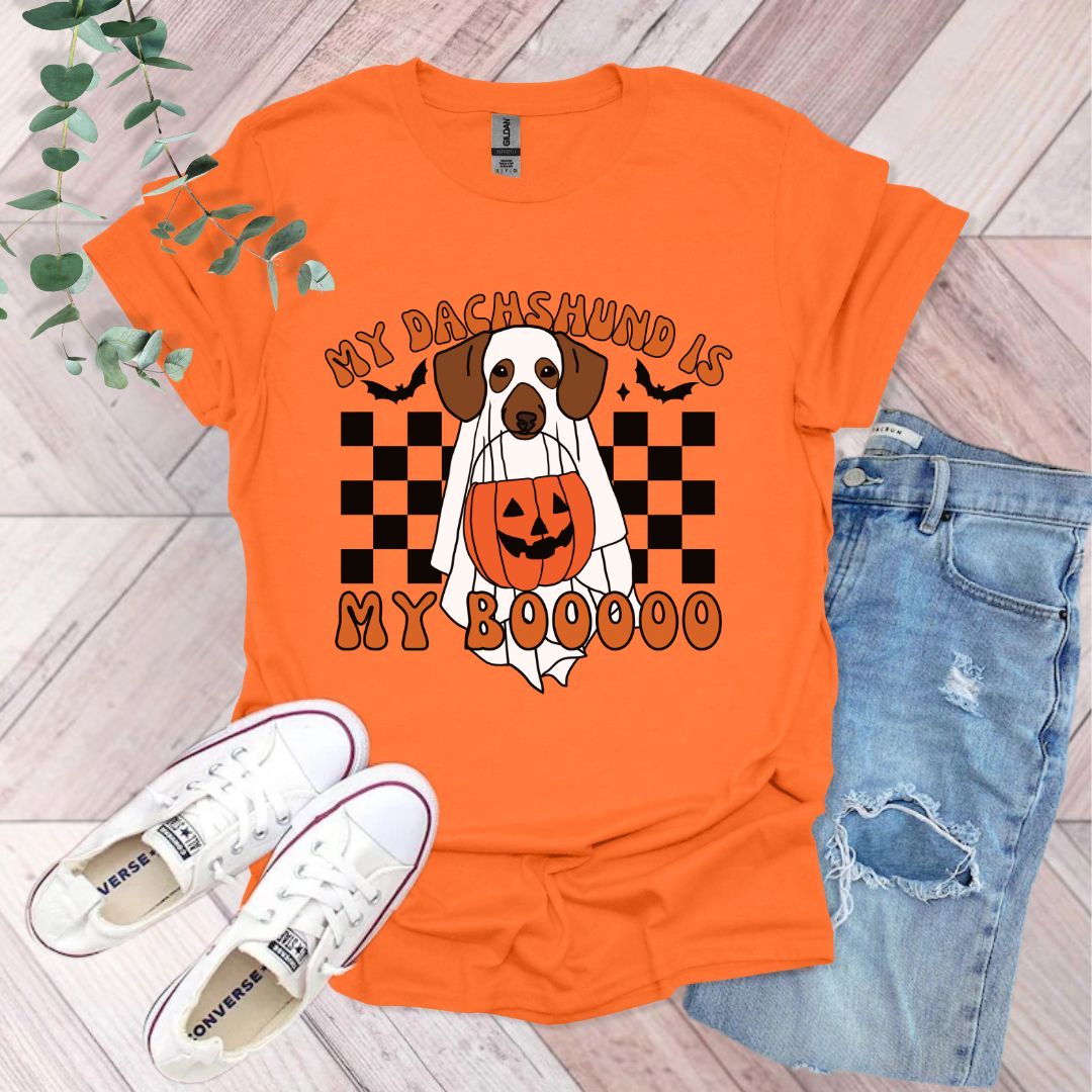 an orange shirt with a dog wearing a pumpkin on it