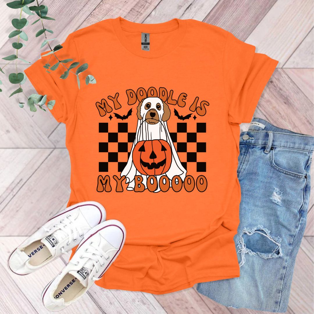 an orange shirt with a dog wearing a jack o lantern on it