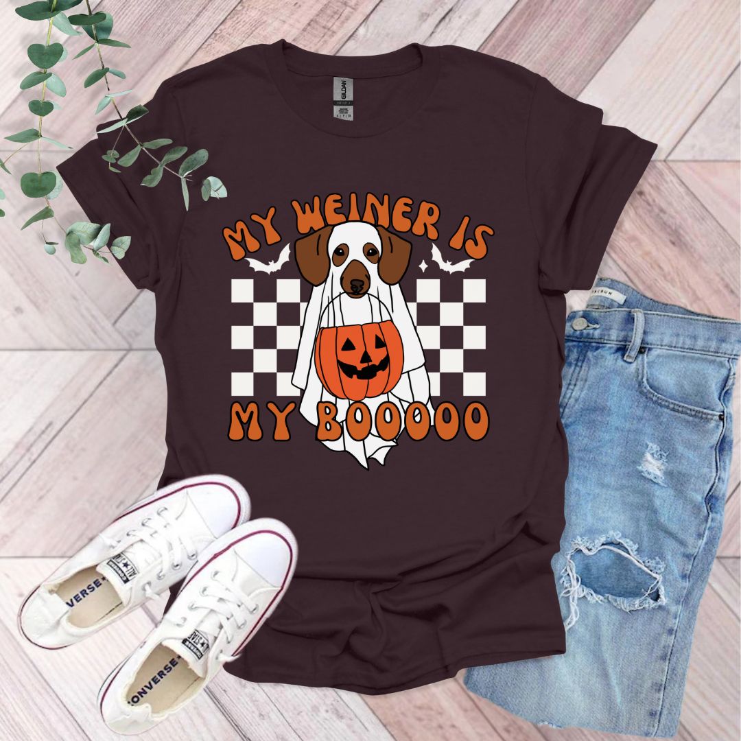 a brown and white dog wearing a pumpkin shirt