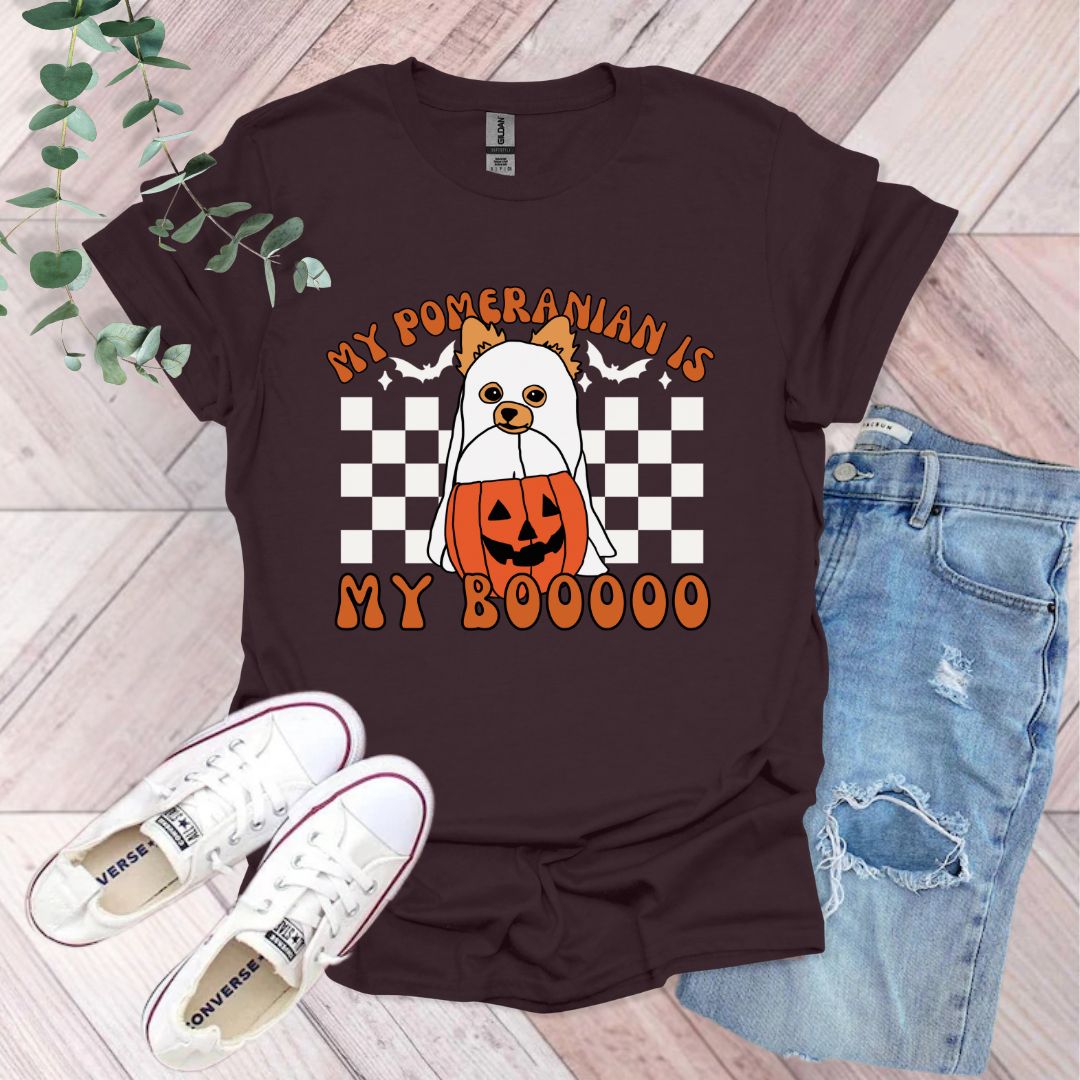 a t - shirt with a picture of a dog holding a pumpkin