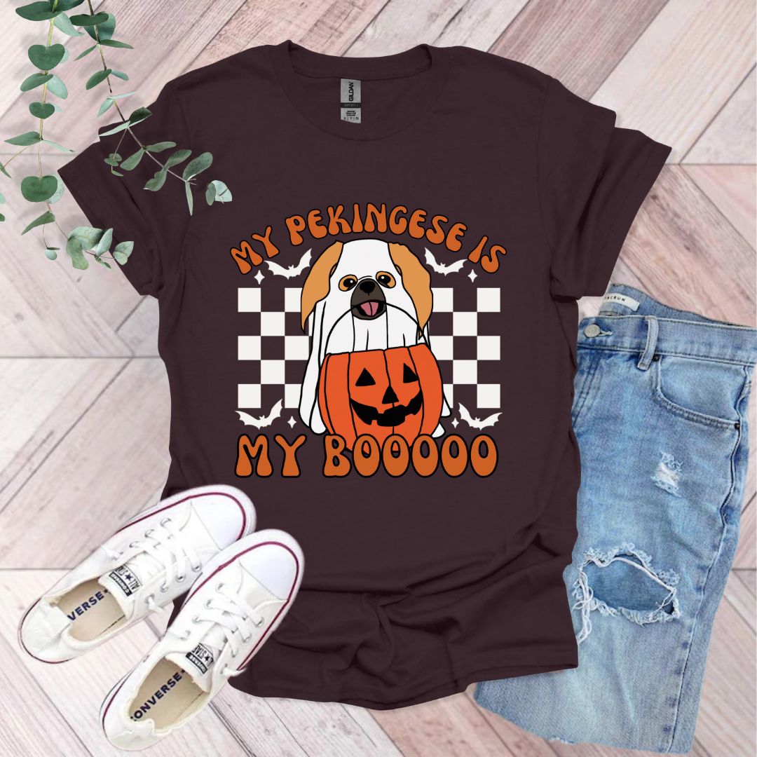 a dog wearing a pumpkin shirt with a jack o lantern on it