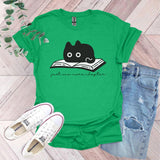 a green shirt with a black cat reading a book