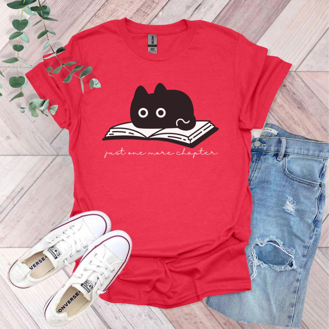 a red shirt with a black cat reading a book