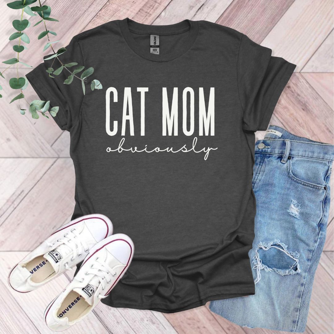 a t - shirt that says cat mom university next to a pair of jeans