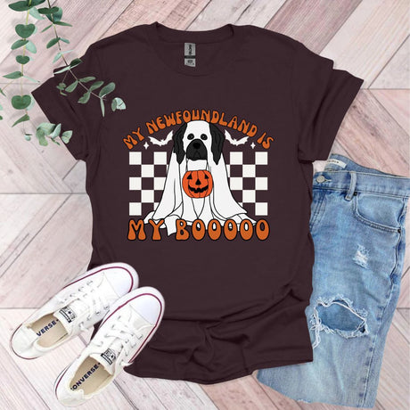 a black and white dog wearing a pumpkin shirt
