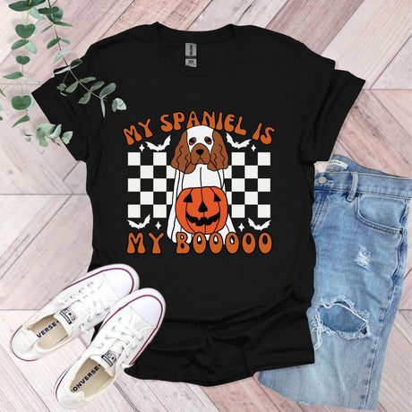 a black shirt with a brown and white dog wearing a pumpkin on it