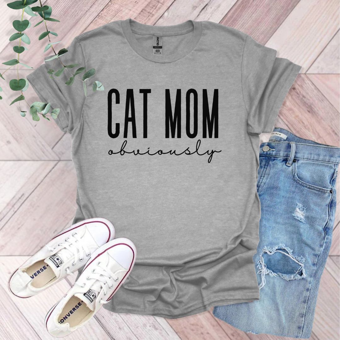 a t - shirt that says cat mom university next to a pair of ripped jeans