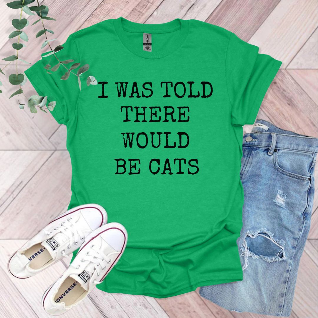 a green shirt that says i was told there would be cats